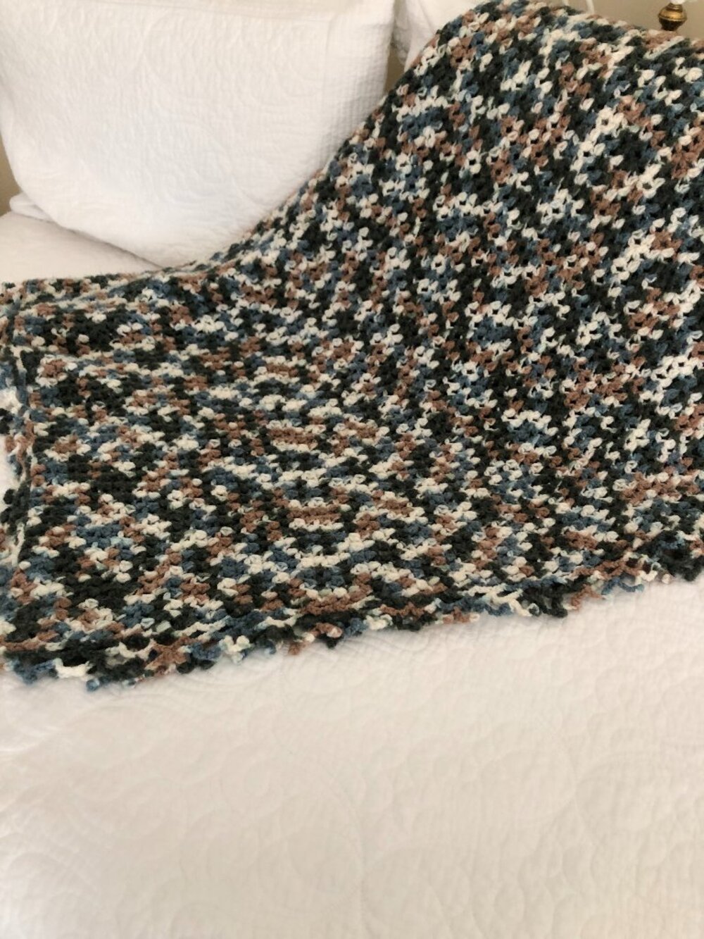 Handmade crocheted blue, brown, and white afghan